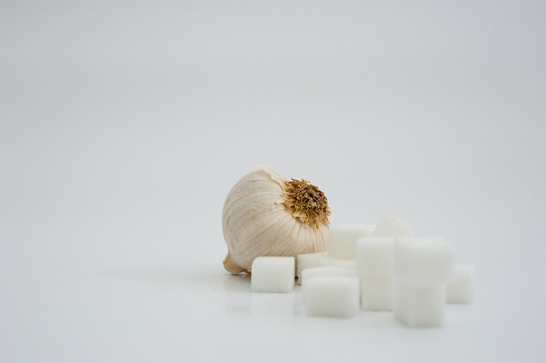 A garlic with some sugar cubes - Photo, Image