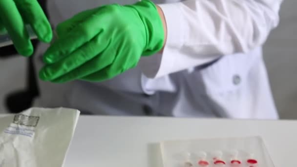 Female medical laboratory worker makes blood test - Filmati, video