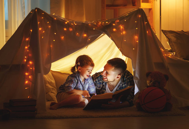 heureux père de famille et fille enfant lisant un livre dans la tente
  - Photo, image