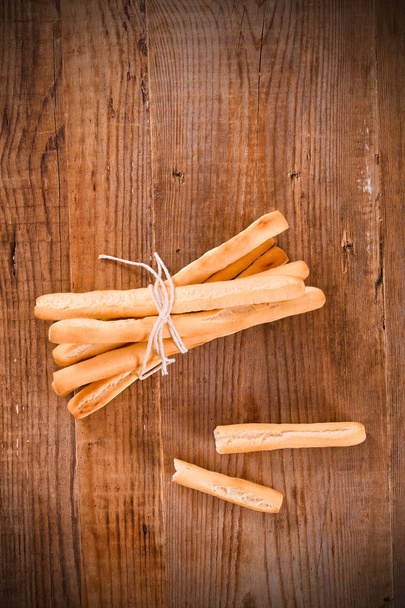 Palitos de pan sobre mesa de madera
.  - Foto, Imagen