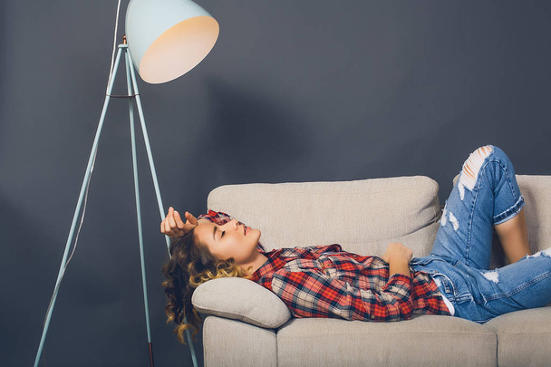 Молодая женщина лежит на диване
 - Фото, изображение