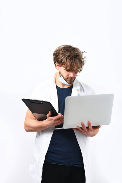 Bearded caucasian doctor or postgraduate student with laptop and clipboard - Photo, Image