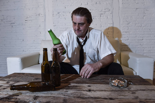 hombre alcohólico desordenado en corbata suelta en casa sala de estar sofá beber botella de cerveza emborracharse
 - Foto, imagen