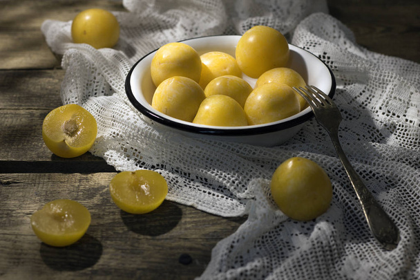 Still life with yellow plums in a white bowl. - Foto, Imagen
