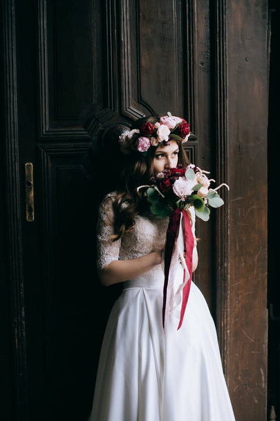 Bride in wreath with wedding bouquet - Fotoğraf, Görsel