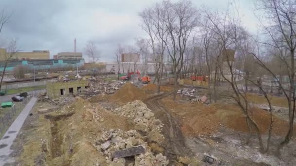 building remains and excavator loads truck - Materiał filmowy, wideo