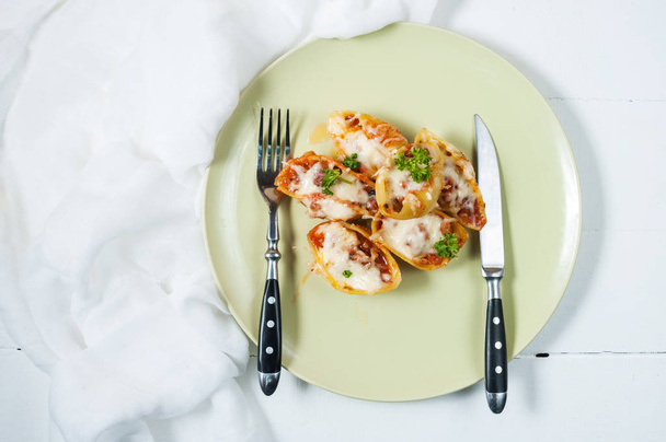 Conchigliei pasta gevuld met ricotta kaas, mozzarella en vlees op witte houten tafel. - Foto, afbeelding