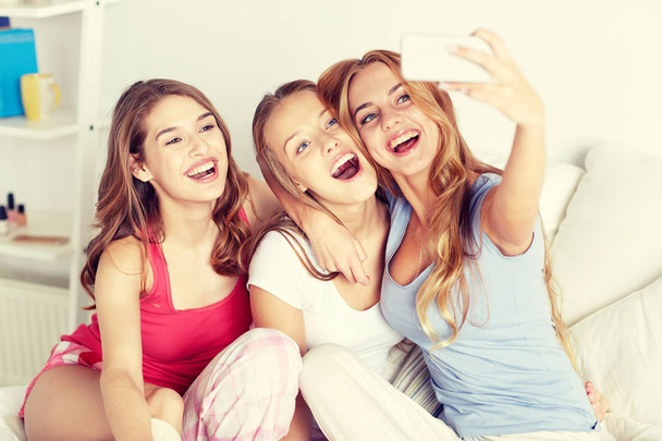 teen girls with smartphone taking selfie at home - Foto, afbeelding