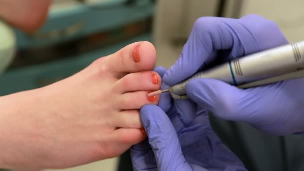 Πεντικιούρ, φροντίδα ποδιών - ένας χειριστής κέντρο ομορφιάς νοιάζεται για τα νύχια των πελατών της - Πλάνα, βίντεο