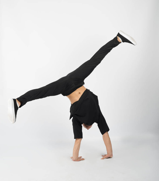 Young muscular breakdancer man stands on his hands - Fotó, kép