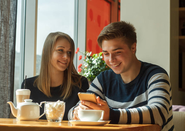 Cheerful couple dating in a cafe and smiling - Фото, зображення
