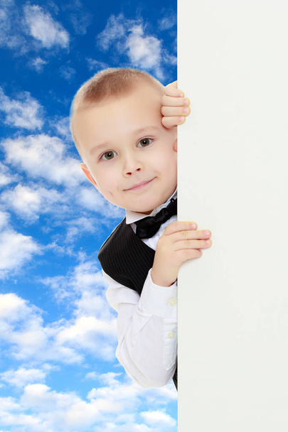 Boy peeping over white banner. - Φωτογραφία, εικόνα