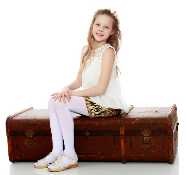 Girl sitting on an old suitcase. - Fotó, kép