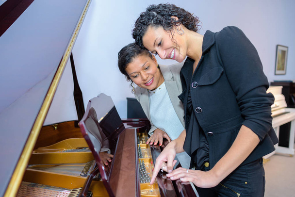 Women looking at piano - Photo, image