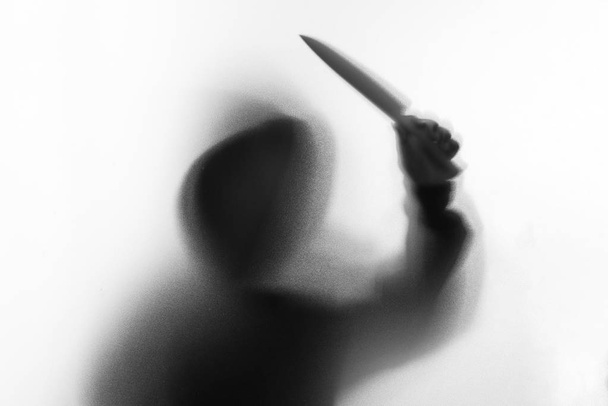 Θόλωσης σκιάς του ανθρώπου τρόμου στο σακάκι με κουκούλα μαχαίρι στο χέρι του. - Φωτογραφία, εικόνα