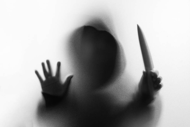 Θόλωσης σκιάς του ανθρώπου τρόμου στο σακάκι με κουκούλα μαχαίρι στο χέρι του. - Φωτογραφία, εικόνα