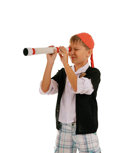 Studio portrait of young boy dressed as pirate with spyglass - Fotó, kép