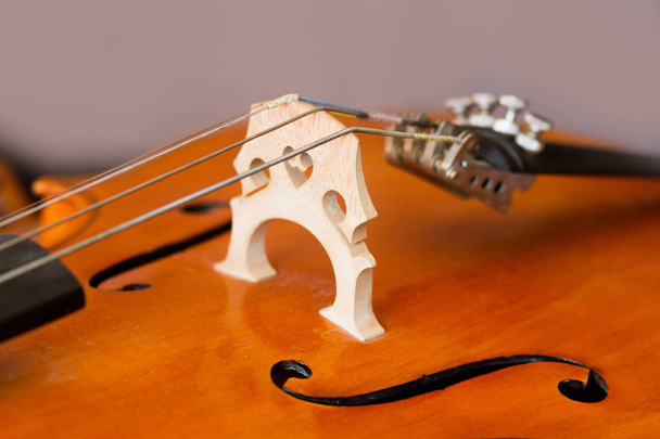 Details eines Violoncello auf beigem Hintergrund - Foto, Bild