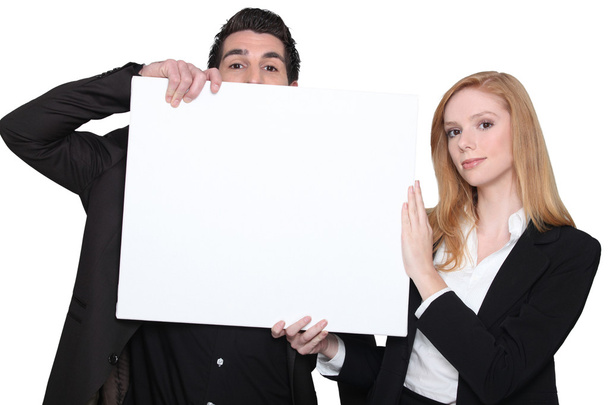 Businessman and businesswoman holding an advertising board - Valokuva, kuva
