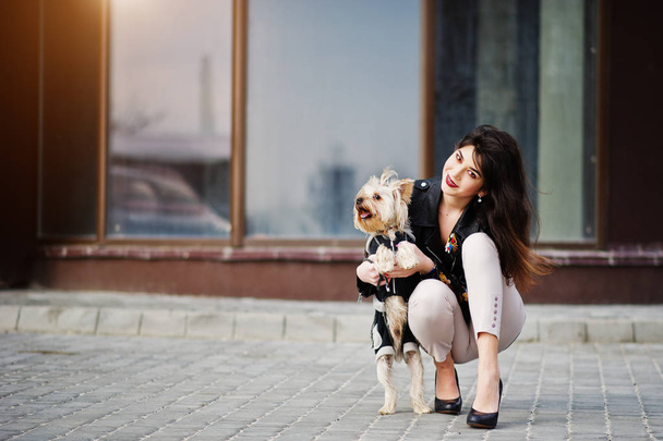 Brunette gypsy girl with yorkshire terrier dog posed against lar - 写真・画像