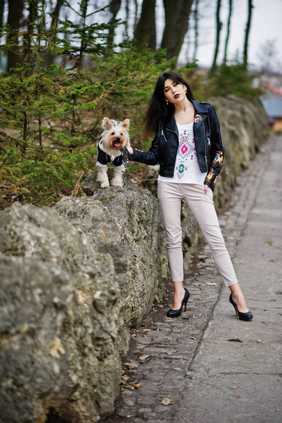 Brunette gypsy girl with yorkshire terrier dog posed against sto - Photo, image