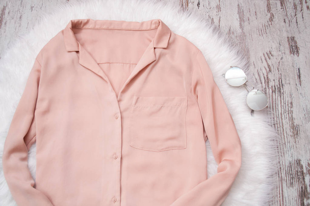 Бледно-розовая блузка на очках из белого меха. Модная концепция, вид сверху
 - Фото, изображение