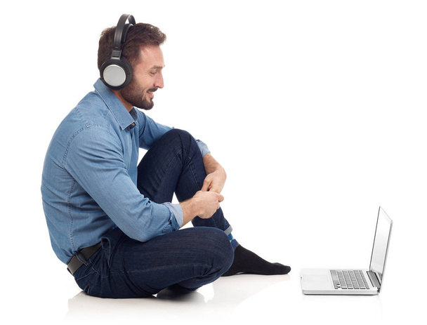 Чоловік розслабляється з ноутбуком і навушниками
 - Фото, зображення