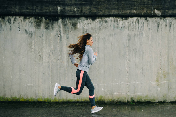 Female urban athlete running outside - Zdjęcie, obraz