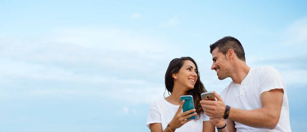 Young couple dating and using smartphones together - Valokuva, kuva