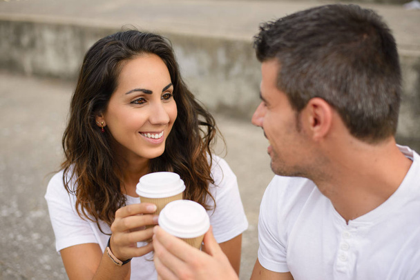 Happy young couple dating and drinking coffee outside - 写真・画像