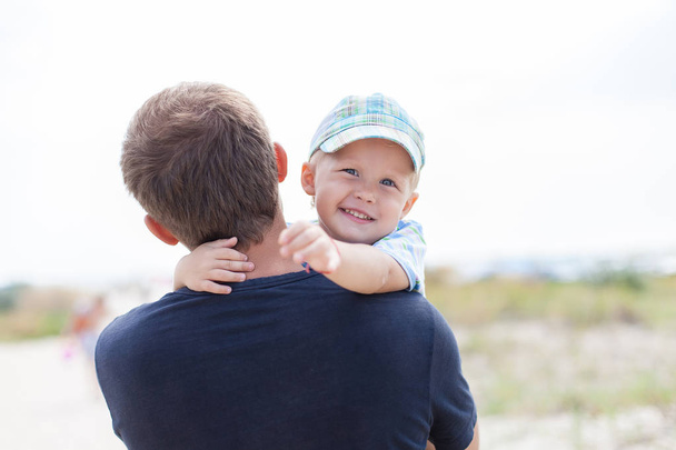 Junge auf den Händen seines Vaters, umarmt, lächelt, lacht, - Foto, Bild