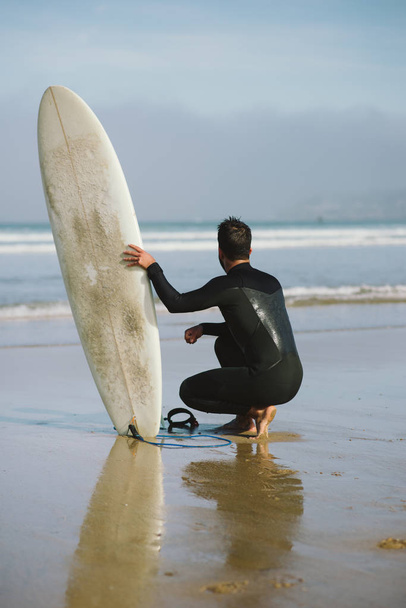 Ready surfer waiting for sea waves before surfing - Foto, Imagem