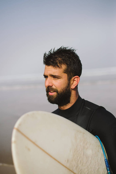 Бородатый серфер покидает море после серфинга
 - Фото, изображение