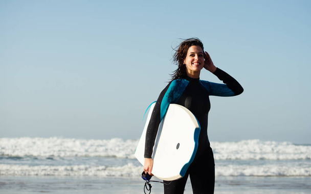 Mujer dejando el con bodyboard después de surfear
 - Foto, imagen
