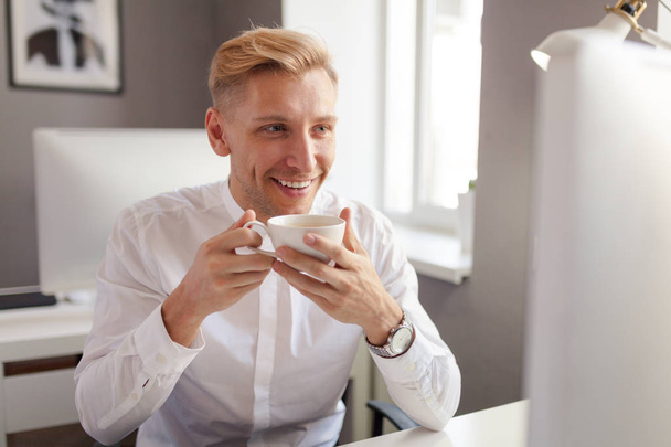 Cheerful office employee with coffee cup - Photo, Image