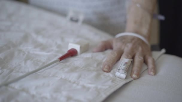 Prise de vue DOF peu profonde de patients âgés main sur le lit
 - Séquence, vidéo