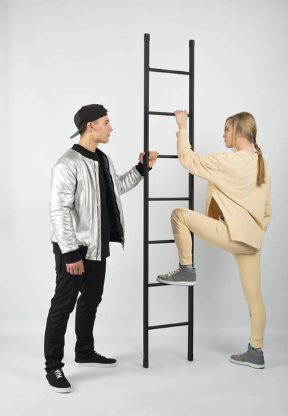 Modern fashionable hipster couple with ladder. - Φωτογραφία, εικόνα