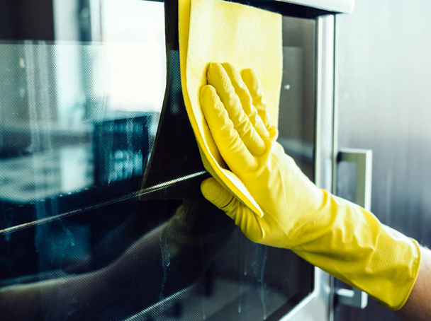 Man's hand cleaning the kitchen oven - Foto, imagen