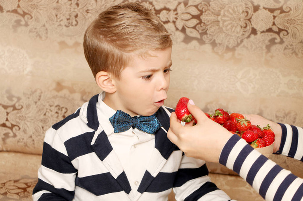  menino comendo morangos
 - Foto, Imagem