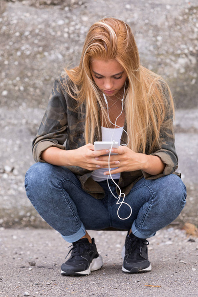 girl plugged into her mobile phone - Foto, Bild