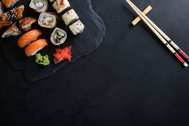 Sushi set with wasabi and ginger on black stone tray on black ta - Valokuva, kuva
