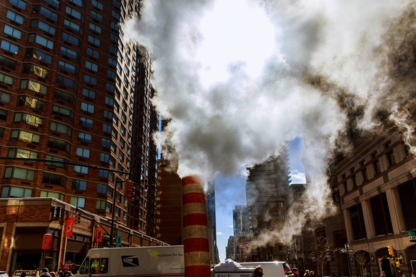 Steam pipe releasing hot air into the street in Midtown Manhattan. - Фото, изображение