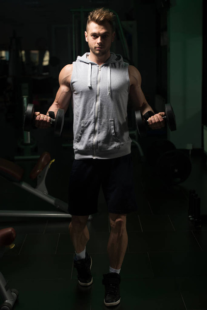 Young Man Doing Exercise For Biceps With Dumbbells - Foto, immagini