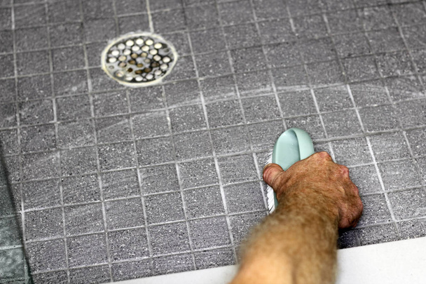 Mies käsi pesu suihku lattia
 - Valokuva, kuva
