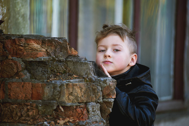 Un garçon regarde derrière un coin. Jeux pour enfants
 - Photo, image