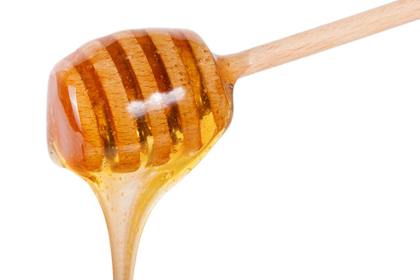 Мед, що тече з дерев'яної палички ізольовано на білому тлі
 - Фото, зображення