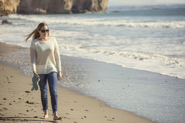 Kobieta spaceru sam przy spokojnej plaży, myśli i rozważania - Zdjęcie, obraz