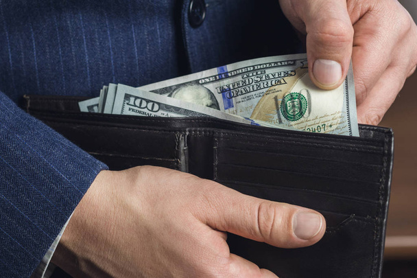 Detailní záběr mužských rukou přebírajících stodolarové bankovky z peněženky, podnikatelského a finančního konceptu - Fotografie, Obrázek