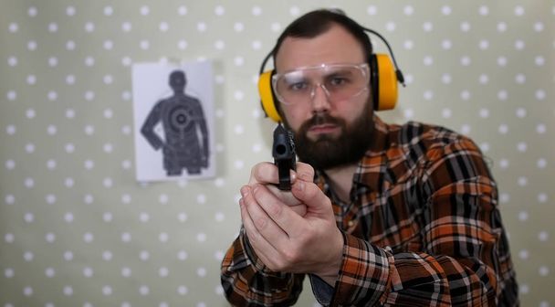 ember, fel a védő szemüveg és fül képzés pisztoly sh - Fotó, kép