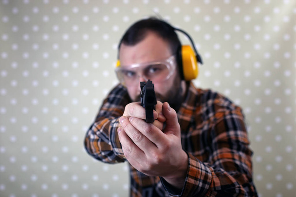 człowiek z kulą w okulary ochronne i ucha szkolenia w pistolet sh - Zdjęcie, obraz